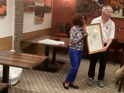 outgoing president Mick presents the new president Sandra with the charter for safekeeping.